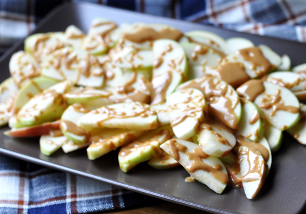 Simple & Healthy Apple Nachos - Step 2 - Drizzle melted peanut butter on top